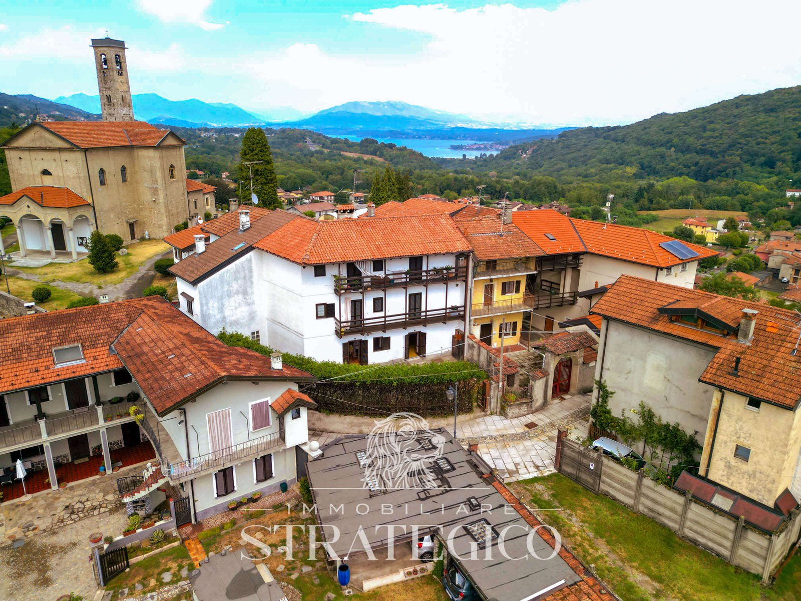 Vista aerea dell’edificio e del borgo di Ghevio, Meina, con il lago sullo sfondo